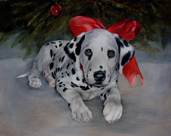 A Dalmatian puppy wearing a red bow in front of a Christmas tree